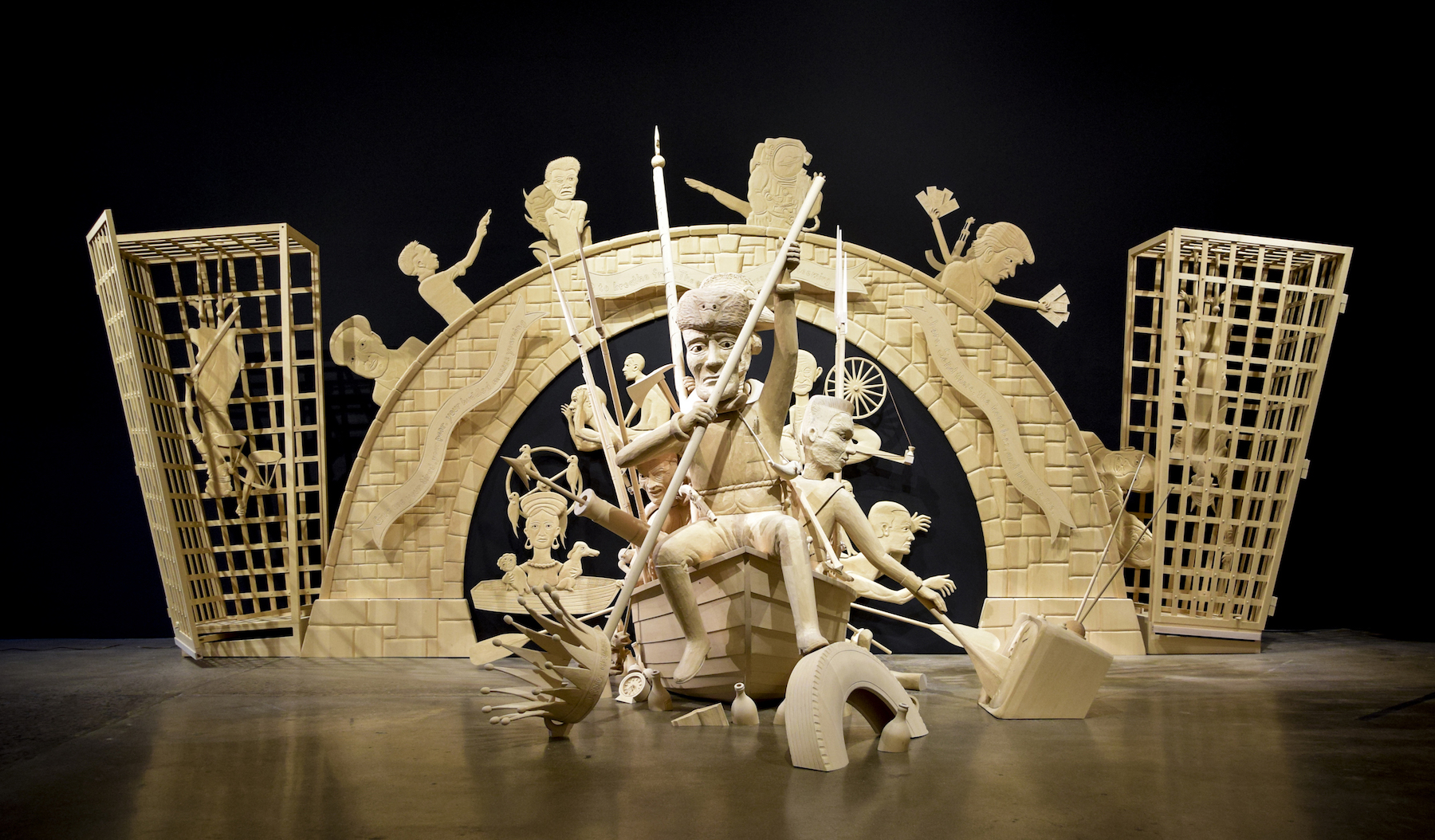 John Buck. The Immigration, 2016; jelutong wood, acrylic paint, leather, motors; 114 x 268 x 168 in. Courtesy of Robischon Gallery.